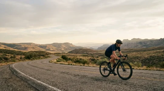 Cycliste en plein effort sur route avec paysage naturel en arrière-plan