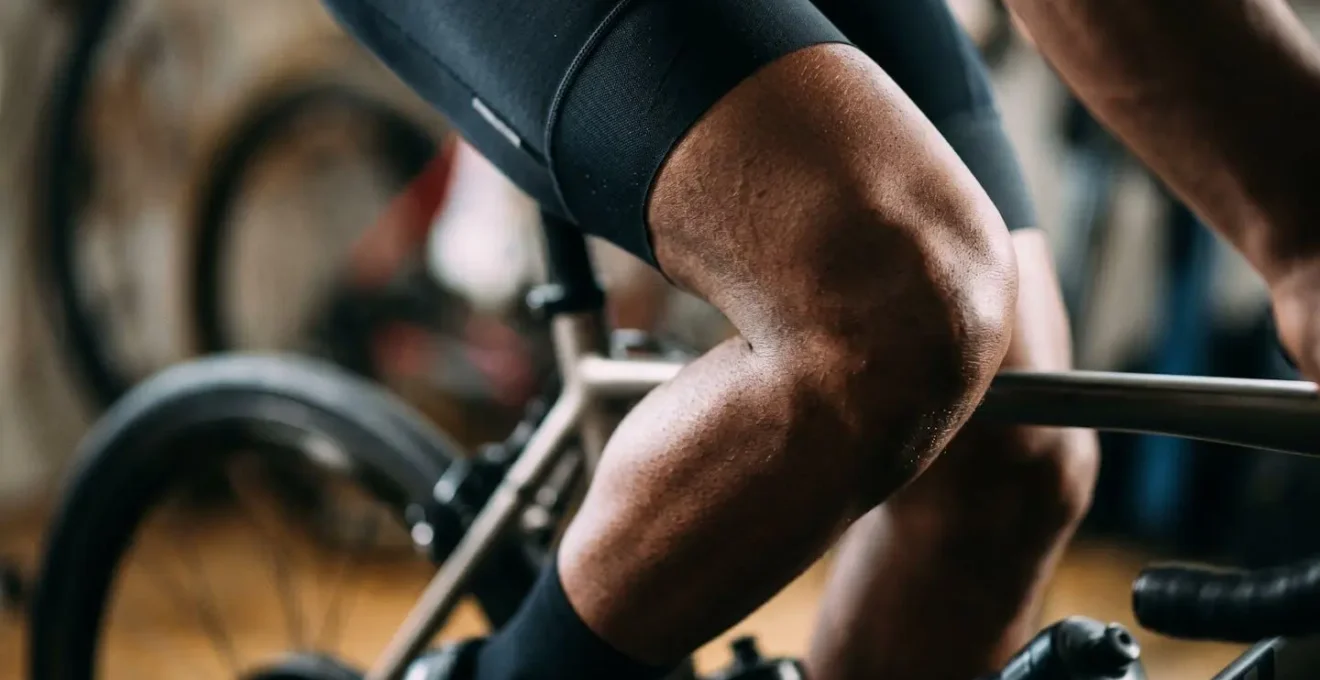Gros plan sur la jambe d'un cycliste en extension maximale sur home trainer montrant l'angle du genou