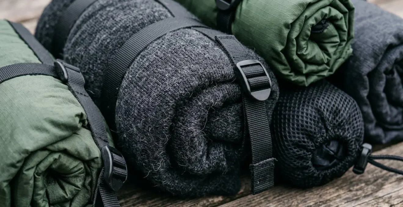 Vue macro sur des vêtements techniques compressés et organisés pour voyage à vélo minimaliste